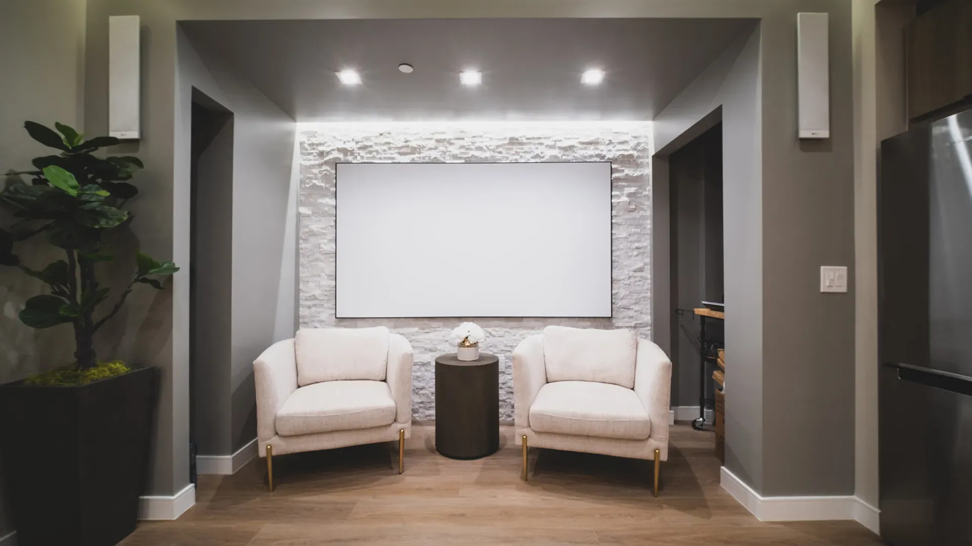 The patient lounge, with two cream armchairs before a white stone wall