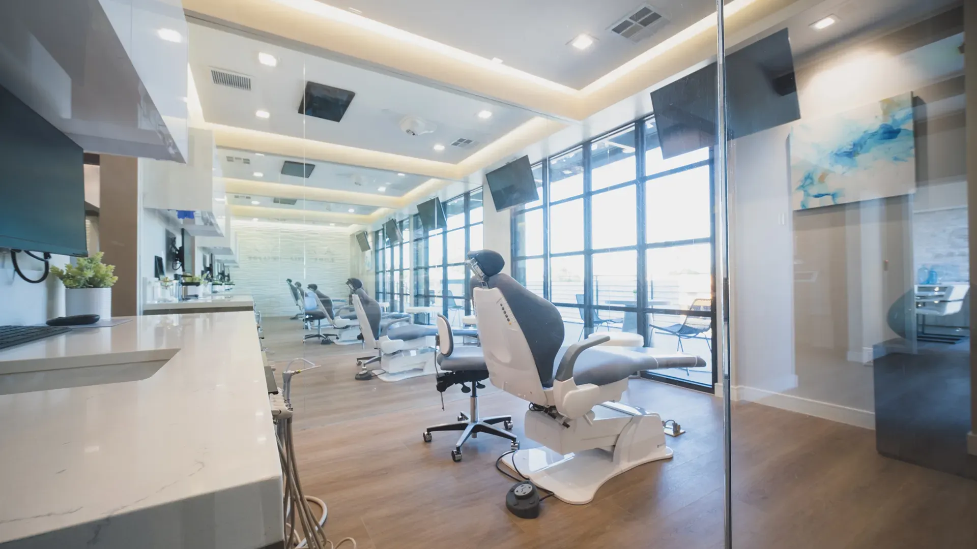 A row of treatment chairs beside floor-to-ceiling windows